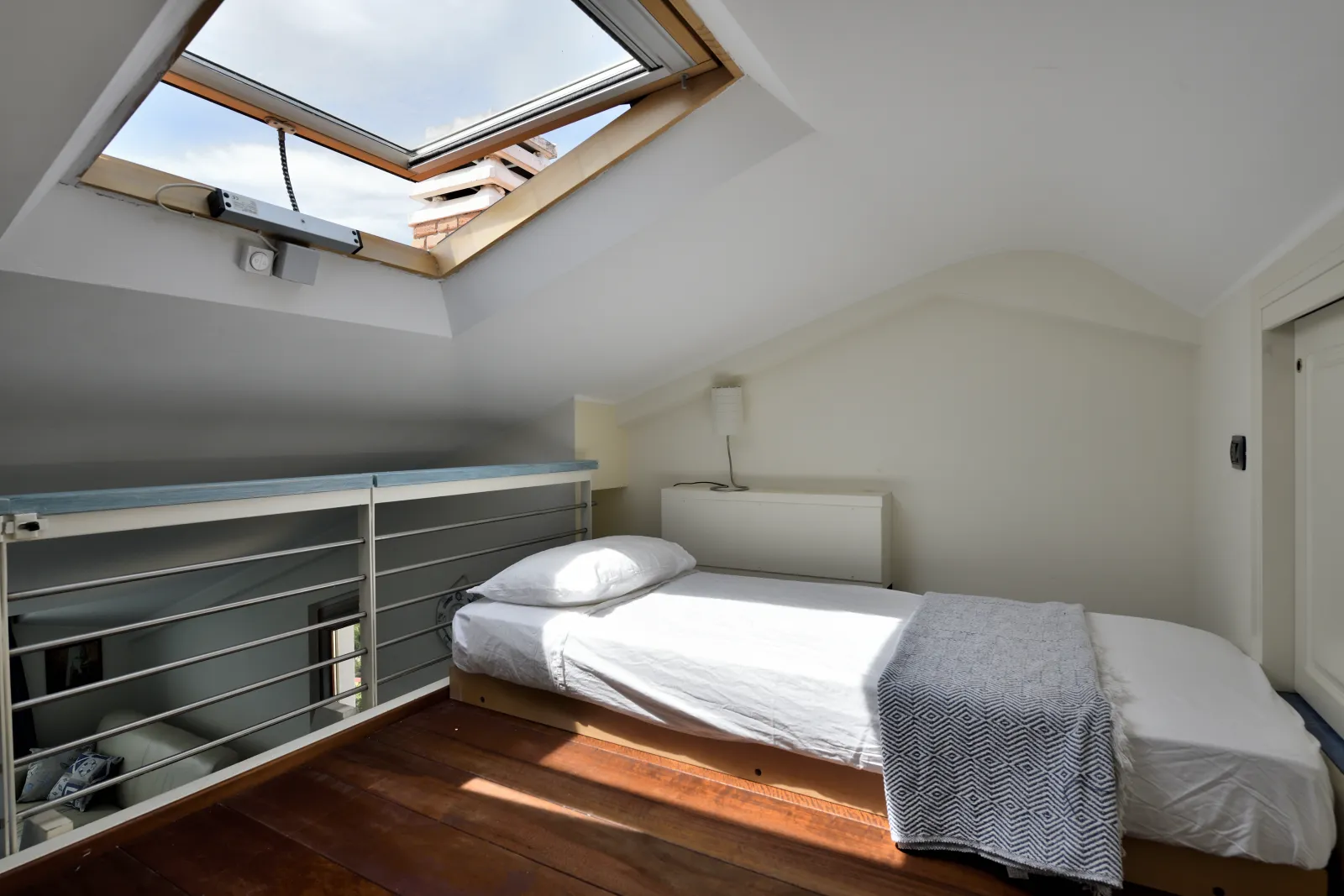 Letto nel soppalco con lucernario
